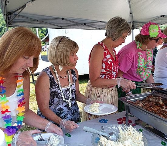Pat Perkins, second from left, and her hula ladies dish out lunch at the Summer Picnic