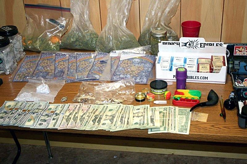 A table arrayed with cash, several kinds of street drugs and paraphernalia seized by police Thursday