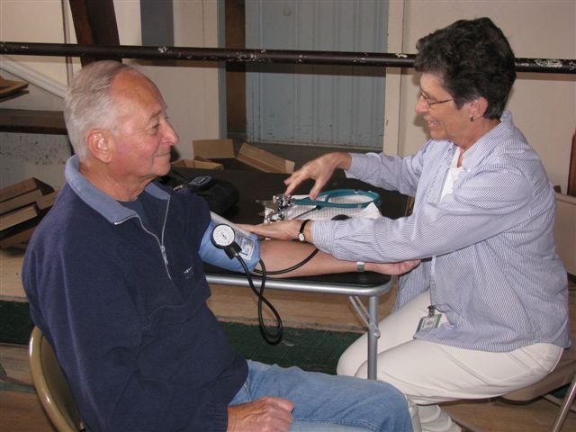 Person Checking Mans Blood Pressure